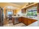 A kitchen with wooden cabinets and stainless steel appliances and view of a dining area by the water through an archway at 1748 Sunset Dr, Clearwater, FL 33755