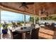 A covered outdoor patio featuring tile floors, ceiling fans, ample seating, and stunning waterfront views at 1748 Sunset Dr, Clearwater, FL 33755