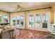 Inviting sun room with tile flooring, multiple french doors, and a ceiling fan for comfortable waterfront living at 1748 Sunset Dr, Clearwater, FL 33755