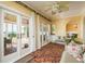Bright sun room with tile flooring, multiple french doors, a ceiling fan, and a cozy seating area at 1748 Sunset Dr, Clearwater, FL 33755