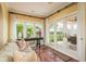 Bright sun room with tile flooring, multiple french doors, a ceiling fan, and a cozy seating area at 1748 Sunset Dr, Clearwater, FL 33755