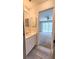 Bathroom sink and mirror viewed from door, adjacent to bedroom with sliding door and ceiling fan at 2113 E Del Webb Blvd, Sun City Center, FL 33573