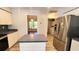 Bright kitchen featuring stainless steel refrigerator, center island, and white cabinets at 2113 E Del Webb Blvd, Sun City Center, FL 33573