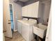 Convenient laundry room featuring a washer, dryer, sink, and storage cabinets at 2113 E Del Webb Blvd, Sun City Center, FL 33573