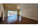 Spacious living room featuring hardwood floors, a ceiling fan, and sliding glass doors to the lanai at 2113 E Del Webb Blvd, Sun City Center, FL 33573