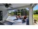 Enclosed patio featuring comfortable seating, ceiling fan, and serene views of the backyard landscaping at 2113 E Del Webb Blvd, Sun City Center, FL 33573