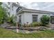 Side view of the white painted brick home, showing the landscaping and dark trimmed windows at 2305 S Hesperides St, Tampa, FL 33629