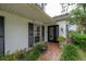 Charming front entrance with a glass paneled front door and brick walkway surrounded by greenery at 2305 S Hesperides St, Tampa, FL 33629