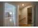 Hallway with hardwood floors leads to room awaiting renovation with fireplace surround at 2305 S Hesperides St, Tampa, FL 33629