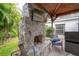 Covered patio with a stone fireplace and mounted flatscreen television for outdoor entertainment at 2305 S Hesperides St, Tampa, FL 33629