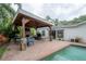 Covered outdoor patio with a stone fireplace, comfortable seating, and views of the pool and backyard at 2305 S Hesperides St, Tampa, FL 33629