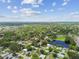 Wide aerial view of a suburban neighborhood featuring mature trees and a picturesque pond at 2401 Havana Dr, Clearwater, FL 33764