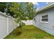 Cozy backyard space enclosed by a white fence and featuring lush green grass at 2401 Havana Dr, Clearwater, FL 33764