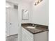 Bathroom featuring granite vanity top and white cabinetry, offering style and storage at 2401 Havana Dr, Clearwater, FL 33764