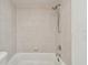 Close-up of clean white tiled bathtub and shower with chrome fixtures, offering a classic, spa-like retreat at 2401 Havana Dr, Clearwater, FL 33764