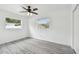 Bright bedroom featuring gray vinyl flooring and two windows for natural light at 2401 Havana Dr, Clearwater, FL 33764