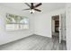 Light, bright bedroom showcasing neutral walls, ceiling fan, and wood-look floors at 2401 Havana Dr, Clearwater, FL 33764