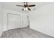Bedroom featuring gray vinyl flooring, closet doors, and a ceiling fan at 2401 Havana Dr, Clearwater, FL 33764