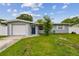 Charming single-story home with a lush front yard, driveway and attached garage at 2401 Havana Dr, Clearwater, FL 33764