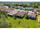 An aerial view showcases the homes in the neighborhood with green lawns and lush landscaping, and community ballfields in background at 3148 Sago Point Ct, Land O Lakes, FL 34639