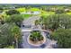 Aerial view of a clubhouse surrounded by mature palm trees and a pristine golf course in the distance at 3148 Sago Point Ct, Land O Lakes, FL 34639