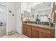Bathroom with double sink vanity, granite countertop, framed mirror, and tile floors at 3148 Sago Point Ct, Land O Lakes, FL 34639