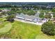 Aerial view of the clubhouse showcasing its large patio, golf cart parking, and meticulously maintained golf course surroundings at 3148 Sago Point Ct, Land O Lakes, FL 34639