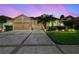 Charming single-story home with a three-car garage, manicured lawn, and tropical landscaping at 3148 Sago Point Ct, Land O Lakes, FL 34639