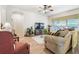 Comfortable living room showcasing a ceiling fan, large windows, and cozy furniture at 3148 Sago Point Ct, Land O Lakes, FL 34639