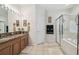 Main bathroom with double sink vanity, framed mirror, tile floors, and glass enclosed shower and tub at 3148 Sago Point Ct, Land O Lakes, FL 34639