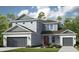 Two-story home with gray siding, gray roof, a two car garage and nicely manicured green grass at 3405 Lumber Falls Dr, Plant City, FL 33565