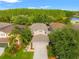 Aerial view of a well-maintained home featuring a spacious backyard, mature trees, and manicured landscaping at 3434 Tarbolton Way, Land O Lakes, FL 34638