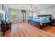 Comfortable bedroom with wood floors, ceiling fan, and ample natural light creates a relaxing retreat at 3434 Tarbolton Way, Land O Lakes, FL 34638