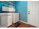 Practical laundry room with modern washer and dryer, storage cabinets, and convenient access to the exterior at 3434 Tarbolton Way, Land O Lakes, FL 34638