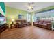 Spacious living room featuring hardwood floors, sofas, and a ceiling fan at 3434 Tarbolton Way, Land O Lakes, FL 34638