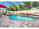 Beautiful pool area enclosed with a screen, brick pavers, and a red umbrella at 3434 Tarbolton Way, Land O Lakes, FL 34638