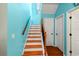 Bright staircase featuring wood treads, white risers, and a decorative wrought iron railing under a skylight at 3434 Tarbolton Way, Land O Lakes, FL 34638