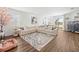 Open-concept living room with hardwood floors and a plush sectional sofa for relaxing and entertaining at 37587 Mackenzie Dr, Zephyrhills, FL 33540