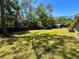 Expansive backyard featuring a lush lawn, a wooden fence, and mature trees for added privacy at 4310 Lithia Pinecrest Rd, Valrico, FL 33596