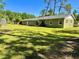 The home's sprawling backyard offers ample green space, surrounded by trees and showcasing the property's size at 4310 Lithia Pinecrest Rd, Valrico, FL 33596