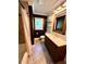 Well-lit bathroom with a tub shower, dark walls, and a dark wood vanity at 4310 Lithia Pinecrest Rd, Valrico, FL 33596