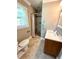Neutral bathroom with stone-tiled shower, modern vanity, and bright window at 4310 Lithia Pinecrest Rd, Valrico, FL 33596