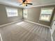 Spacious bedroom features neutral carpet, crown moulding, and three bright windows at 4310 Lithia Pinecrest Rd, Valrico, FL 33596