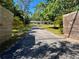 Long driveway framed by wooden fences and lush greenery, leading to a charming home at 4310 Lithia Pinecrest Rd, Valrico, FL 33596