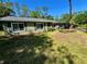 Charming single-story home featuring a well-maintained lawn, dark shutters, and verdant landscaping at 4310 Lithia Pinecrest Rd, Valrico, FL 33596