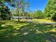 Sprawling front yard leading to a charming single-story home with mature trees providing shade at 4310 Lithia Pinecrest Rd, Valrico, FL 33596