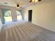 Living room with light-colored walls, plush carpeting, and abundant natural light through double doors at 4310 Lithia Pinecrest Rd, Valrico, FL 33596