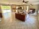 Open-concept living room and kitchen with tile floors, neutral colors, and a sliding glass door at 4310 Lithia Pinecrest Rd, Valrico, FL 33596