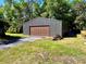 Metal shed with garage door and adjacent driveway providing additional storage at 4310 Lithia Pinecrest Rd, Valrico, FL 33596