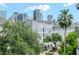 Beautiful building exterior with lush greenery and a skyline view in the background at 450 Knights Run Ave # 414, Tampa, FL 33602
